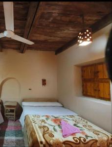 een slaapkamer met een bed in een kamer met een plafond bij Nour El Waha Hotel in Siwa