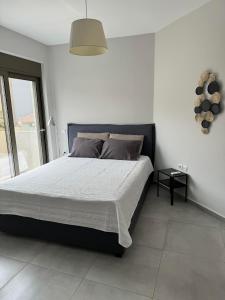 a bedroom with a large bed in a white room at Zonapartments B sea view- city center in Chania