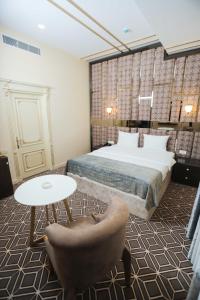 1 dormitorio con 1 cama, 1 mesa y 1 silla en The Krone en Baku