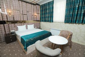 Schlafzimmer mit einem Bett, einem Tisch und Stühlen in der Unterkunft The Krone in Baku