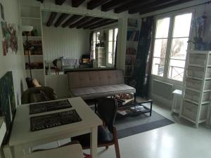 ein Wohnzimmer mit einem Sofa und einem Tisch mit einer Tastatur in der Unterkunft L'appartement florentin in Saint-Germain-en-Laye