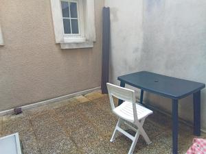 einem blauen Tisch und einem weißen Stuhl neben einem Fenster in der Unterkunft L'appartement florentin in Saint-Germain-en-Laye