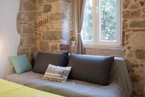 a couch sitting in a room with a window at Old Town Historic Core in Split