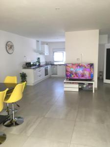 ein großes Wohnzimmer mit einem großen Flachbild-TV in der Unterkunft Maison avec jacuzzi in Saintes