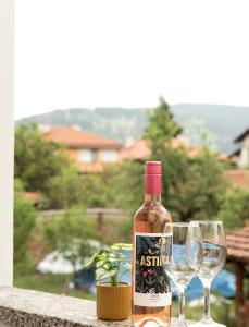 een fles wijn naast twee wijnglazen bij Momento Apartment in Kyustendil