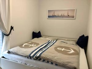 a small bedroom with a bed with a blanket at Janines Loft - Am Marktplatz Steinhude - 190 Meter zum Meer in Steinhude