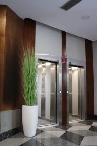 a large white pot with a plant in a lobby at HOTEL ARZÚA in Arzúa