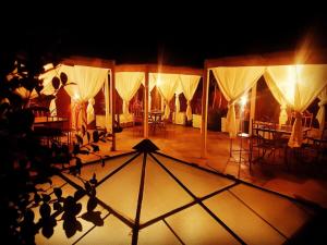 a group of tents with tables and chairs on a stage at Riad Ksar Aylan in Ouarzazate