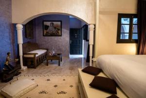 a bedroom with a bed and a room with a table at Riad Ksar Aylan in Ouarzazate +18 photos