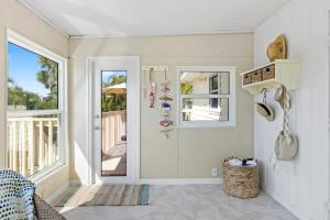 a white room with a door and a balcony at On the Rocks- Gorgeous Newly Renovated Pool Home in Sanibel