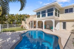 a house with a swimming pool in front of a house at On the Rocks- Gorgeous Newly Renovated Pool Home in Sanibel +13 photos