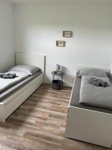 1 dormitorio con 2 camas y suelo de madera en FeWo-Ichenhausen, en Ichenhausen