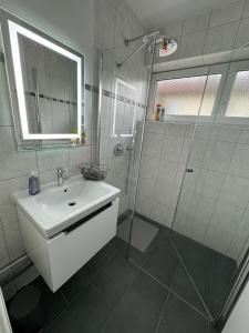y baño blanco con lavabo y ducha. en FeWo-Ichenhausen, en Ichenhausen