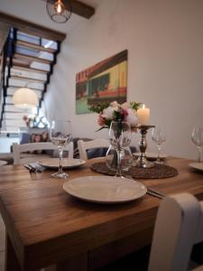 a wooden table with plates and glasses and flowers on it at Apartament 451 in Karpacz
