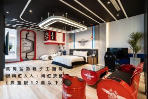 台中市にあるAquarius Motelのベッドと赤い椅子が備わるホテルルームです。