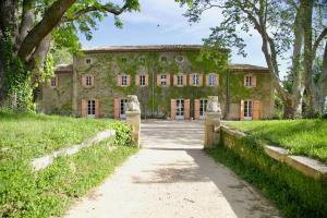 una vieja casa de piedra con un camino delante de ella en Chambres d'hôtes B&B - Château de Sienne proche Avignon Orange Piscine Rivière, en Chusclan