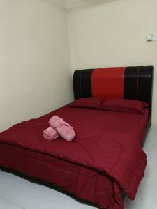 a red bed with a pink stuffed animal on it at Healing Homestay in Kangar