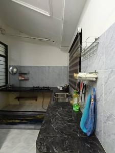 a kitchen with a black counter and a sink at Healing Homestay in Kangar