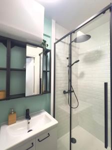 a bathroom with a sink and a glass shower at Provins au coeur du quartier historique - Charmant studio pour 2 in Provins