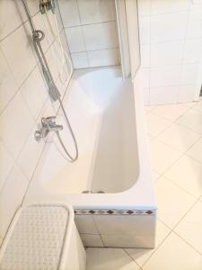 a white bath tub with a shower in a bathroom at Möblierte 5 Zimmer Wohnung in Sulzbach