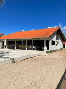 un edificio blanco con techo naranja en una playa en Casa à Beira-mar de Peroba en Peroba