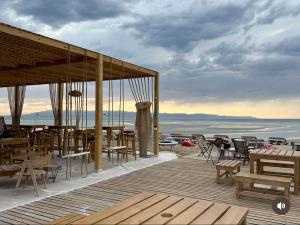 een houten terras met tafels en stoelen op het strand bij la hacienda in Ras Sedr