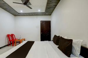 een slaapkamer met een bed en een plafondventilator bij OYO Flagship SAADAR HOTEL AND BANQUET in Kānpur