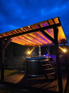 a wooden pergola with a hot tub at night at Munir Chalet in Câmpulung Moldovenesc