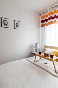 ein weißes Schlafzimmer mit einem Bett und einem Tisch mit Essen darauf in der Unterkunft Wrocław Apartment - Balcony, Park and Tram nearby - by Rentujemy in Breslau