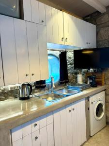a kitchen with a sink and a microwave at The Rock House in Kalo Livadi
