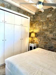 a bedroom with a stone wall and a bed at The Rock House in Kalo Livadi