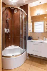 ein Bad mit einer Dusche und einem Waschbecken in der Unterkunft Wrocław Apartment - Balcony, Park and Tram nearby - by Rentujemy in Breslau