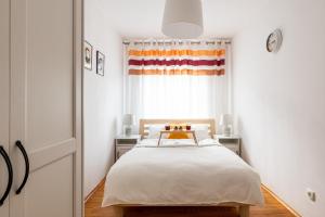 Schlafzimmer mit einem Bett und einem Fenster in der Unterkunft Wrocław Apartment - Balcony, Park and Tram nearby - by Rentujemy in Breslau