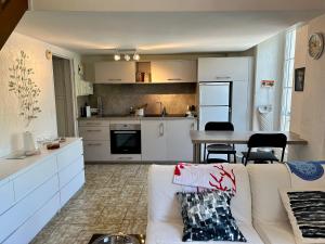 a living room with a couch and a kitchen at Studio avec piscine et tennis in La Garde-Freinet