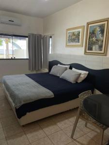 a bedroom with a bed and a chair and a window at Casa à Beira-mar de Peroba in Peroba