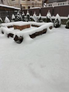 eine schneebedeckte Bank in einem Hof in der Unterkunft Casa Emma in Vişeu de Jos