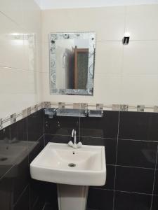 W łazience znajduje się biała umywalka i lustro. w obiekcie Hotel Highway Link w mieście Karaczi