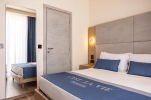 1 dormitorio con 1 cama grande con almohadas azules en C'est La Vie Boutik Swieqi, en Is-Swieqi