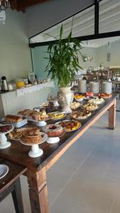 a buffet with many different types of food on a table at Quinta Da Bica D'Agua Village in Florianópolis