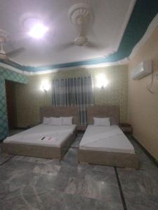 a room with two beds in a room at Hotel Highway Link in Karachi