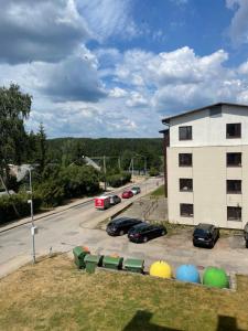 un estacionamiento con autos estacionados al lado de un edificio en Lake apartaments, en Ignalina