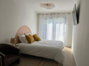 a bedroom with a bed with yellow pillows and a window at Great Room 29 in Mérignac