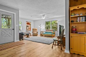 sala de estar con puerta y sala de estar con sofá en Beaverdam Bliss Cabin on 14 acres, en Madison