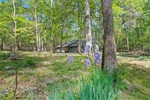 a house in the woods with purple flowers in the yard at Beaverdam Bliss Cabin on 14 acres in Madison