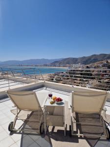 a balcony with two chairs and a table with food on it at Casa Buena Vista con piscina y ascensor in Cullera