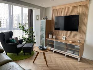 sala de estar con TV de pantalla plana en la pared en Lake apartaments, en Ignalina