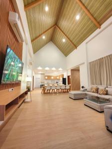un grand salon avec une grande télévision à écran plat dans l'établissement ASTRID PoolVilla KhaoYai, à Pak Chong