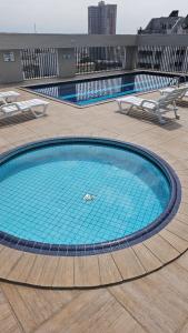 a large swimming pool on top of a building at Apartamento Flat Palladium completo e mobiliado in São Vicente