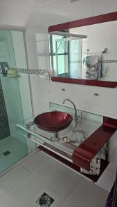 a bathroom with a glass counter with a sink at Apartamento Flat Palladium completo e mobiliado in São Vicente