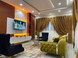 een woonkamer met een gele bank en een tv bij Sall Residence Saly Appartement 2 in Malikounda Sas
